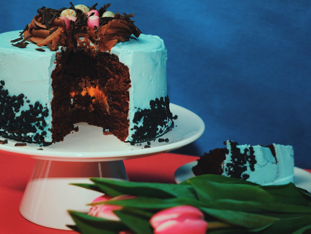 a chocolate cake with blue frosting and a slice taken out of it