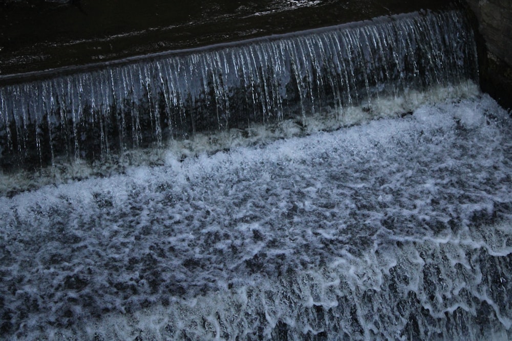the water is flowing down the side of a waterfall