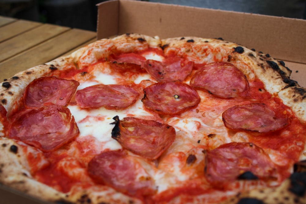 a pepperoni pizza sitting in a box on a table