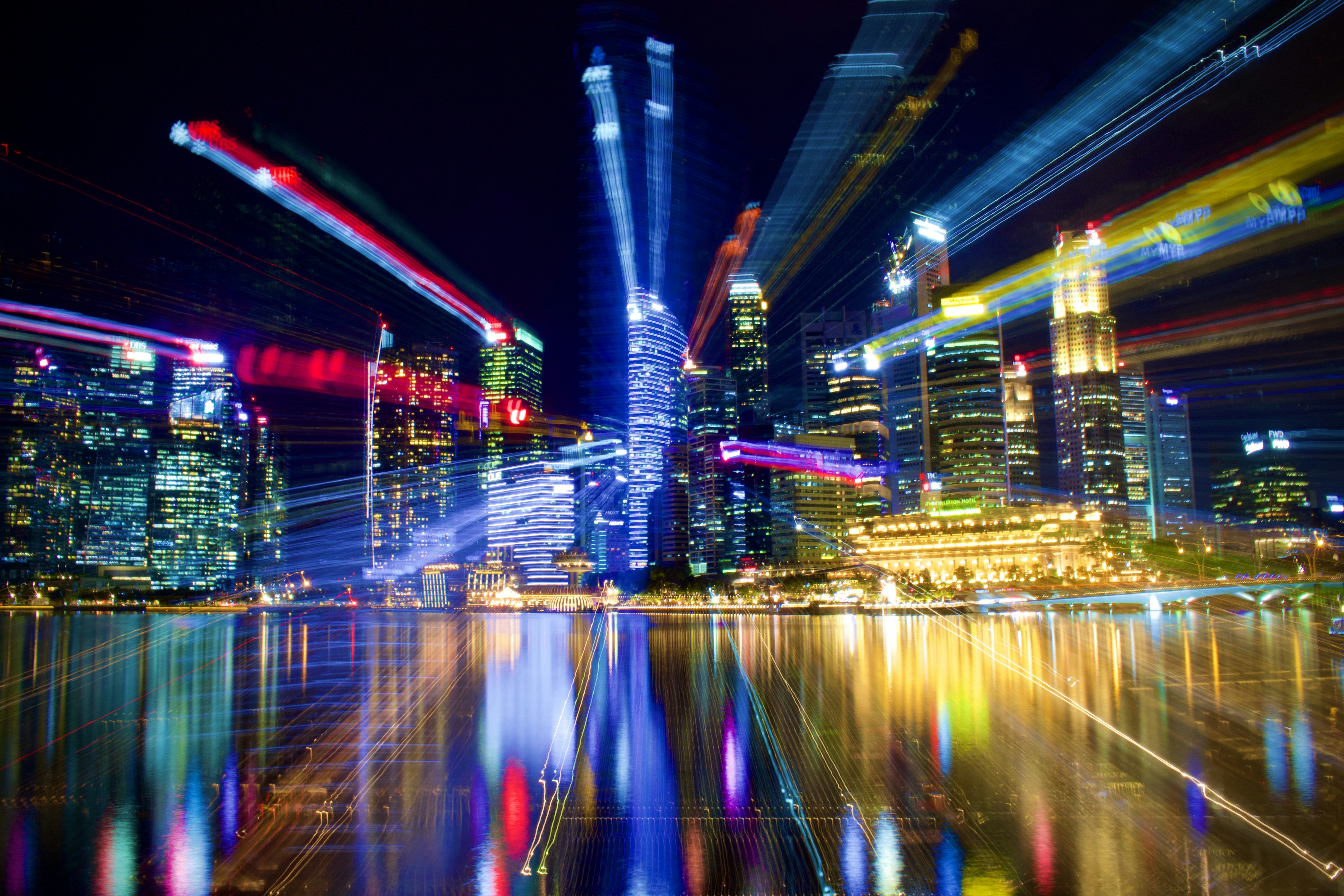 a city at night with lights reflecting in the water