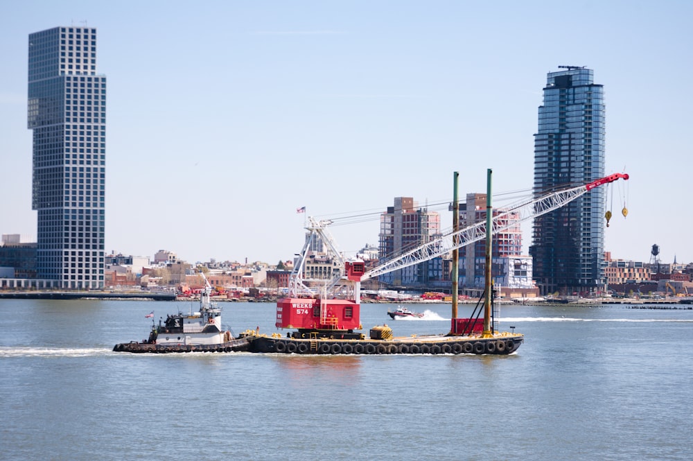 a tug boat in a body of water with a city in the background