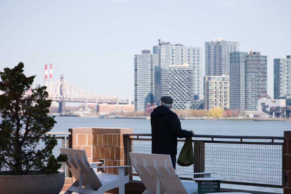 a man standing on a balcony overlooking a city