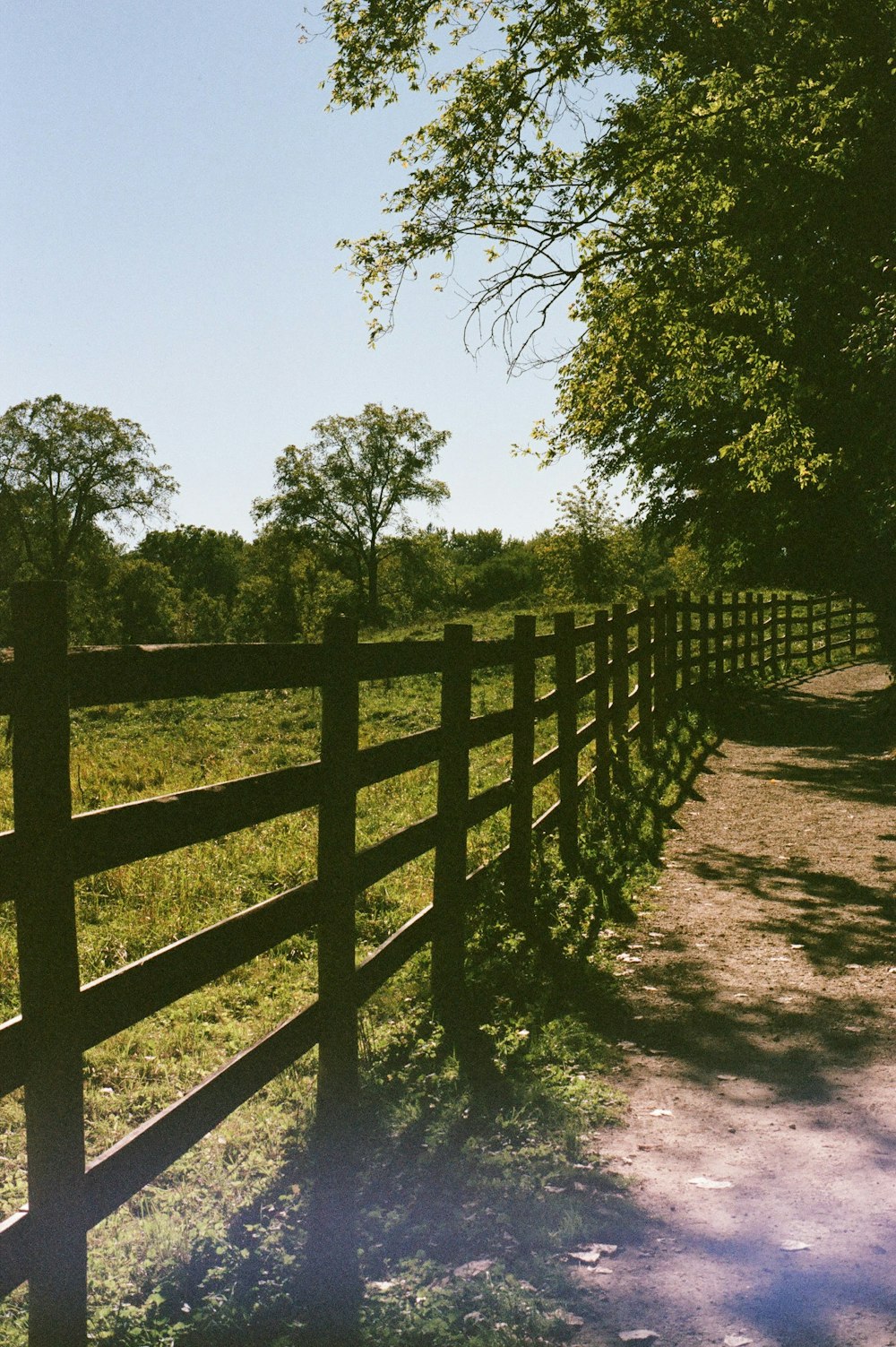 a wooden fence in front of a grassy field