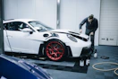 a man working on a white car in a garage