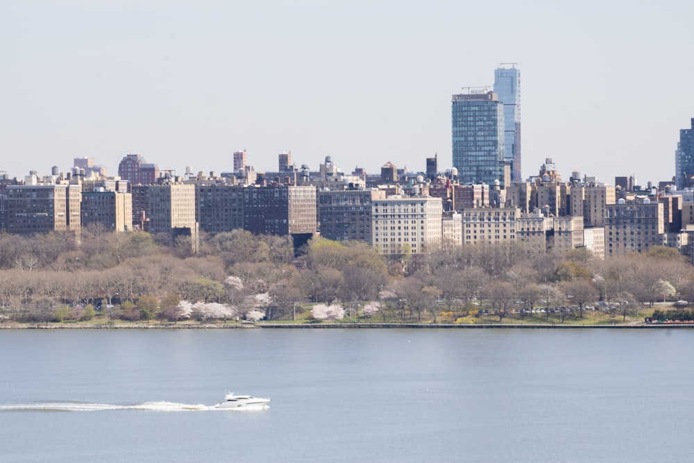 a boat is in the water in front of a large city