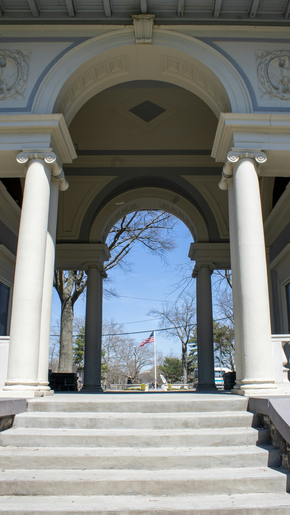 a white building with columns and a flagpole