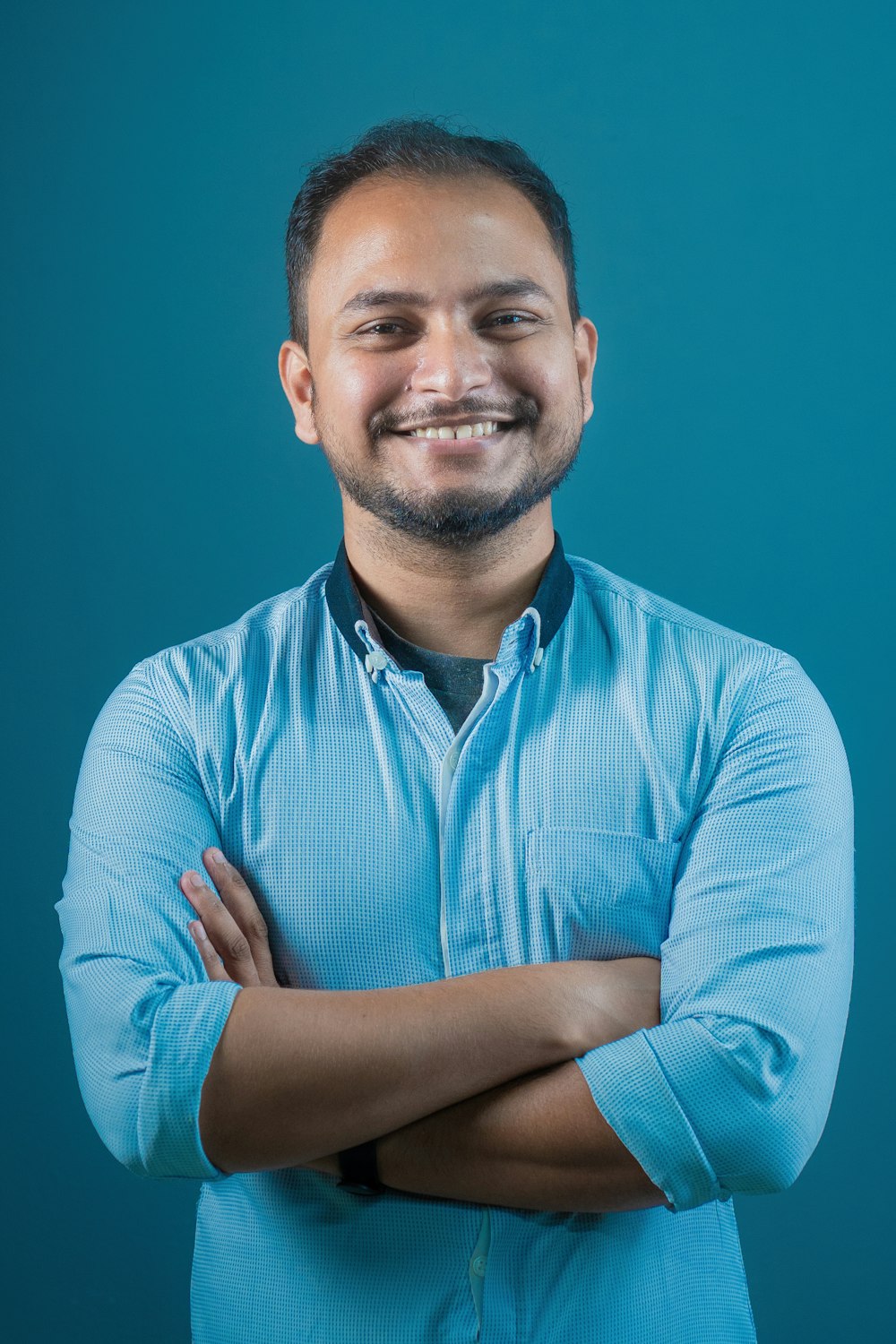 a man with his arms crossed smiling