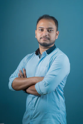 a man with his arms crossed posing for a picture