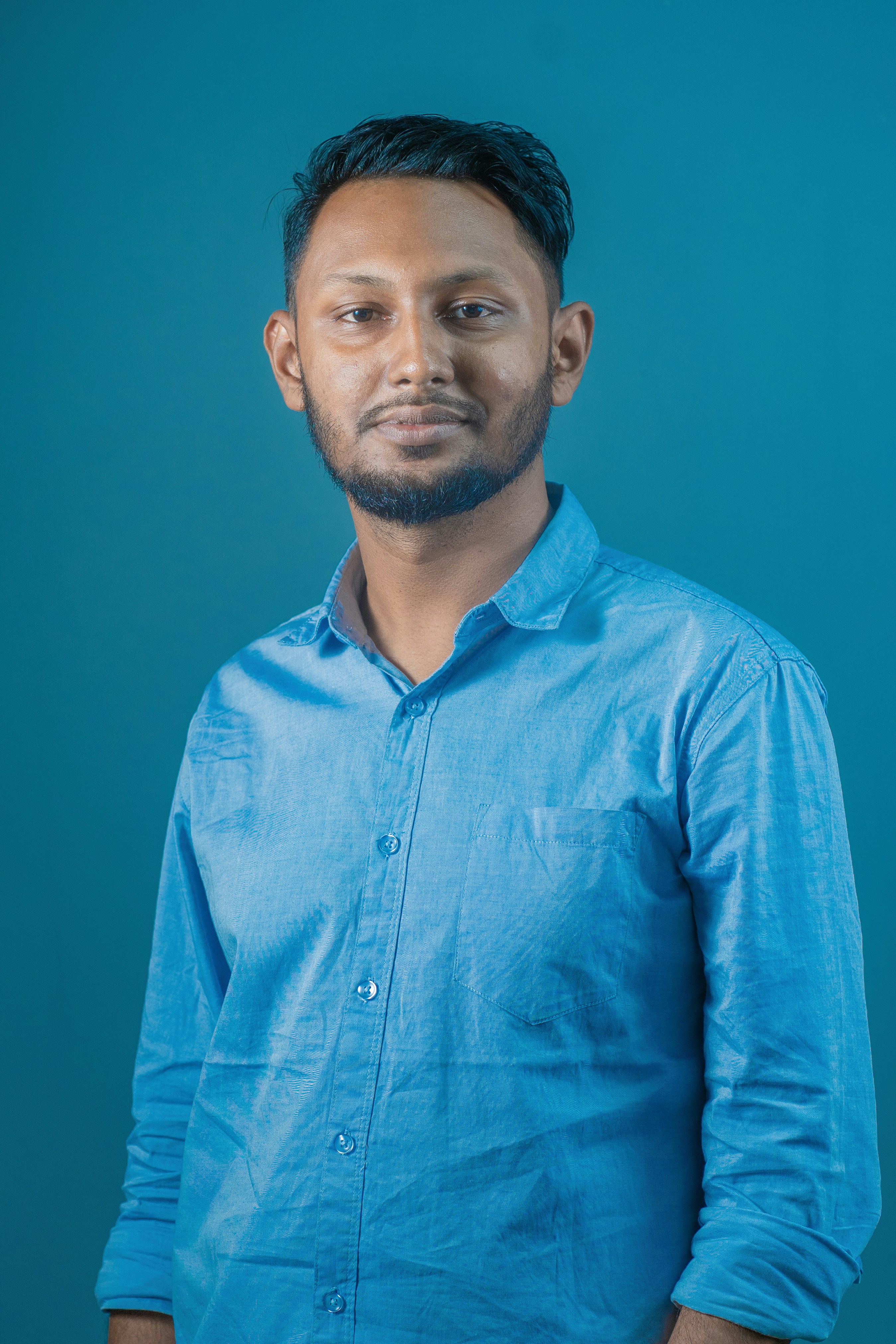 um homem em uma camisa azul posando para uma foto