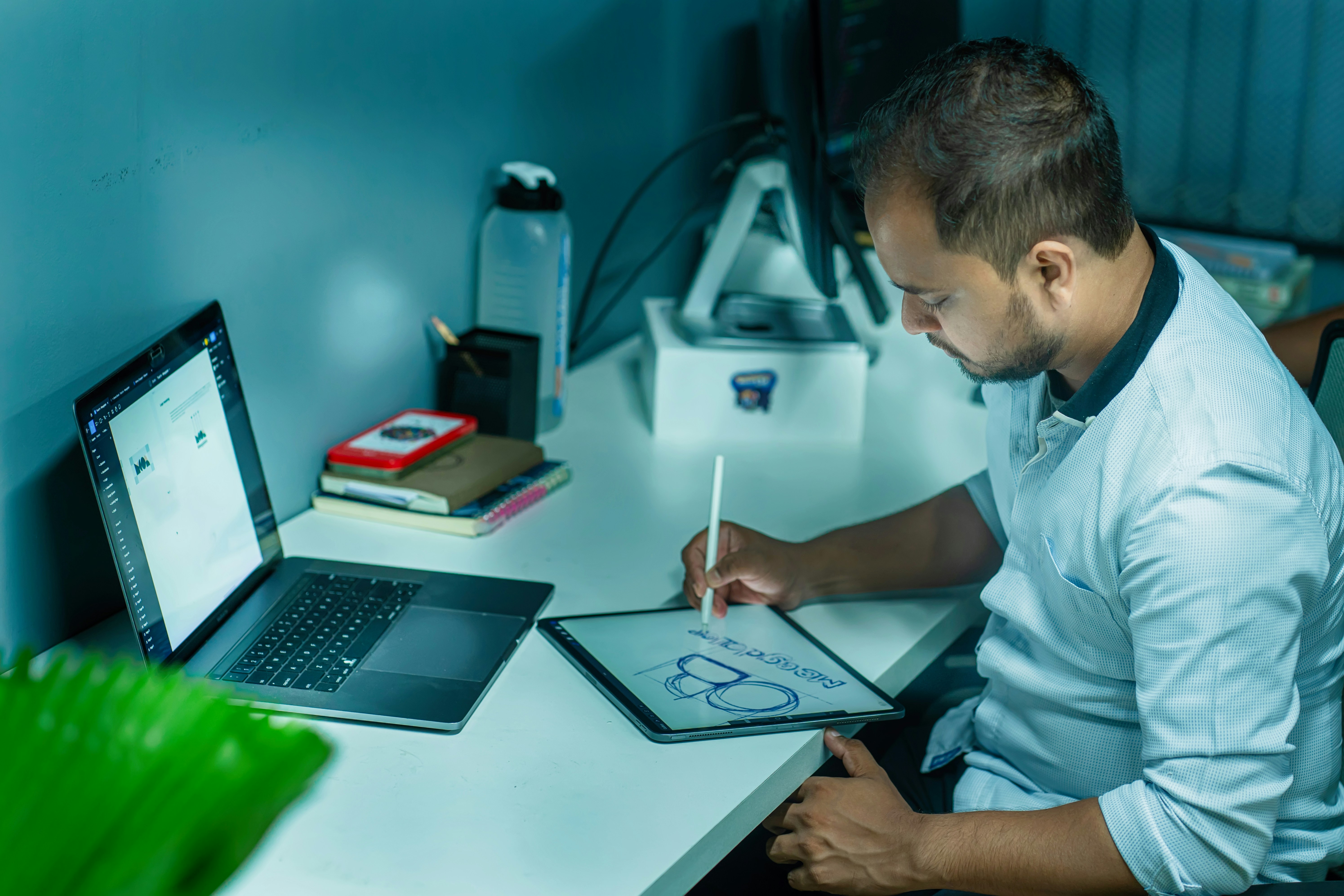 Ein Mann, der an einem Schreibtisch sitzt und auf einem Tablet schreibt