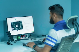 a man sitting in front of a computer monitor