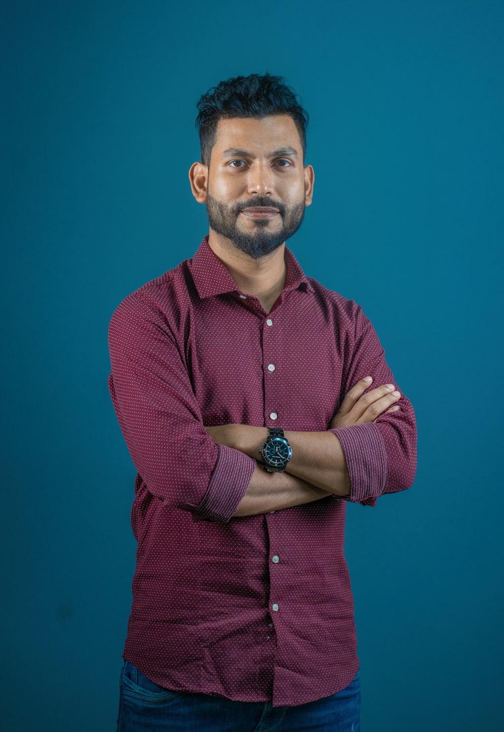 a man with his arms crossed posing for a picture