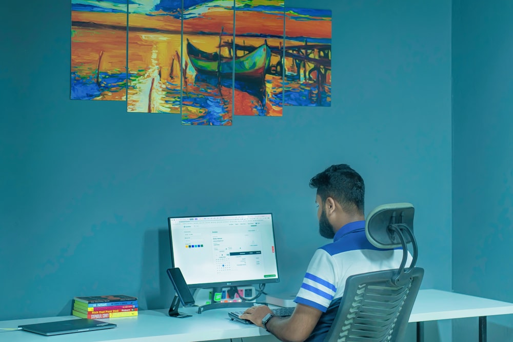 a man sitting at a desk in front of a computer