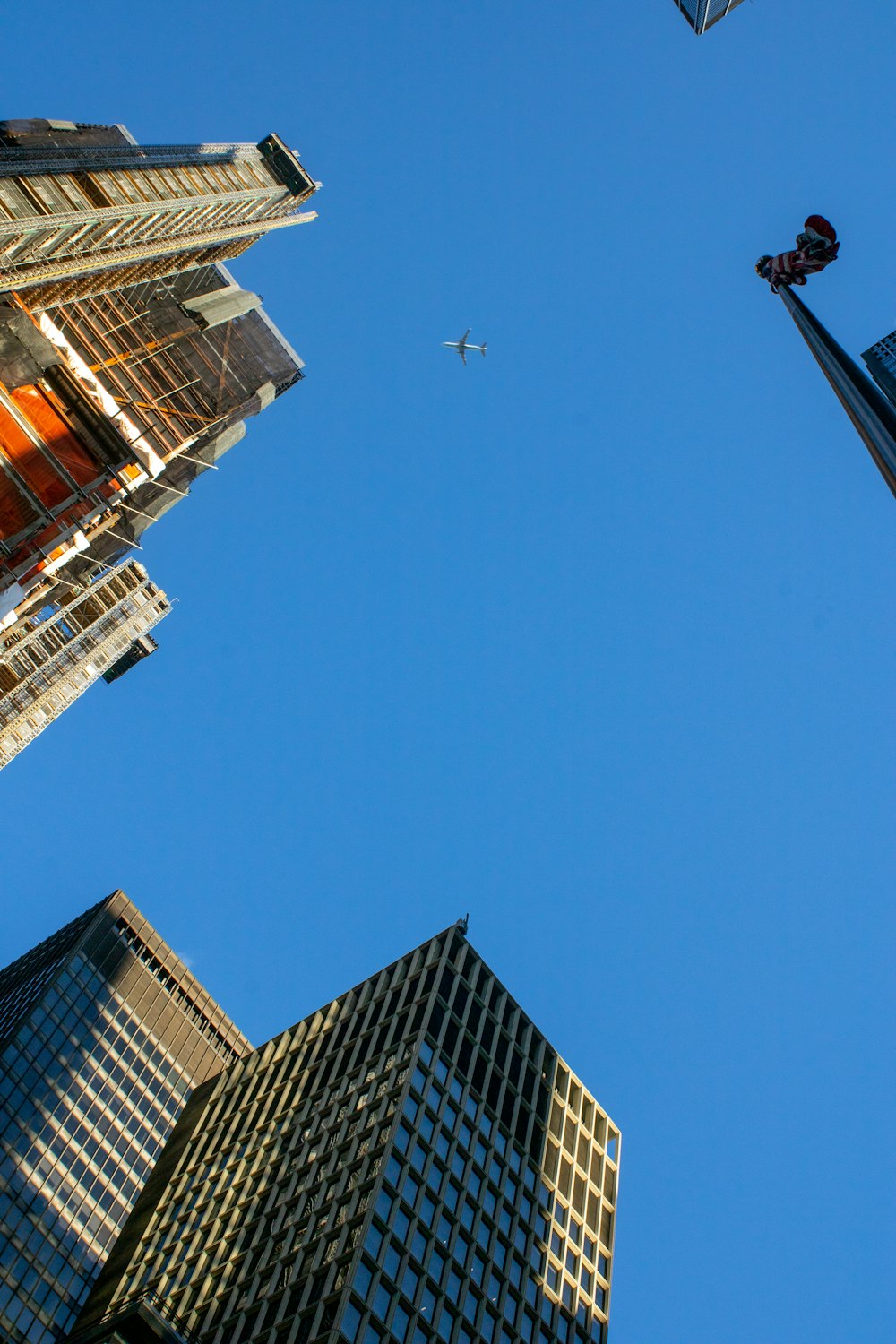 a plane flying in the sky between two tall buildings