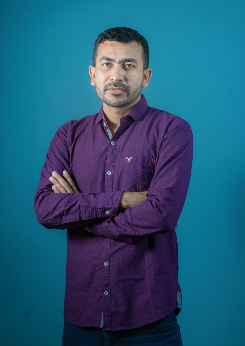 a man in a purple shirt is posing for a picture