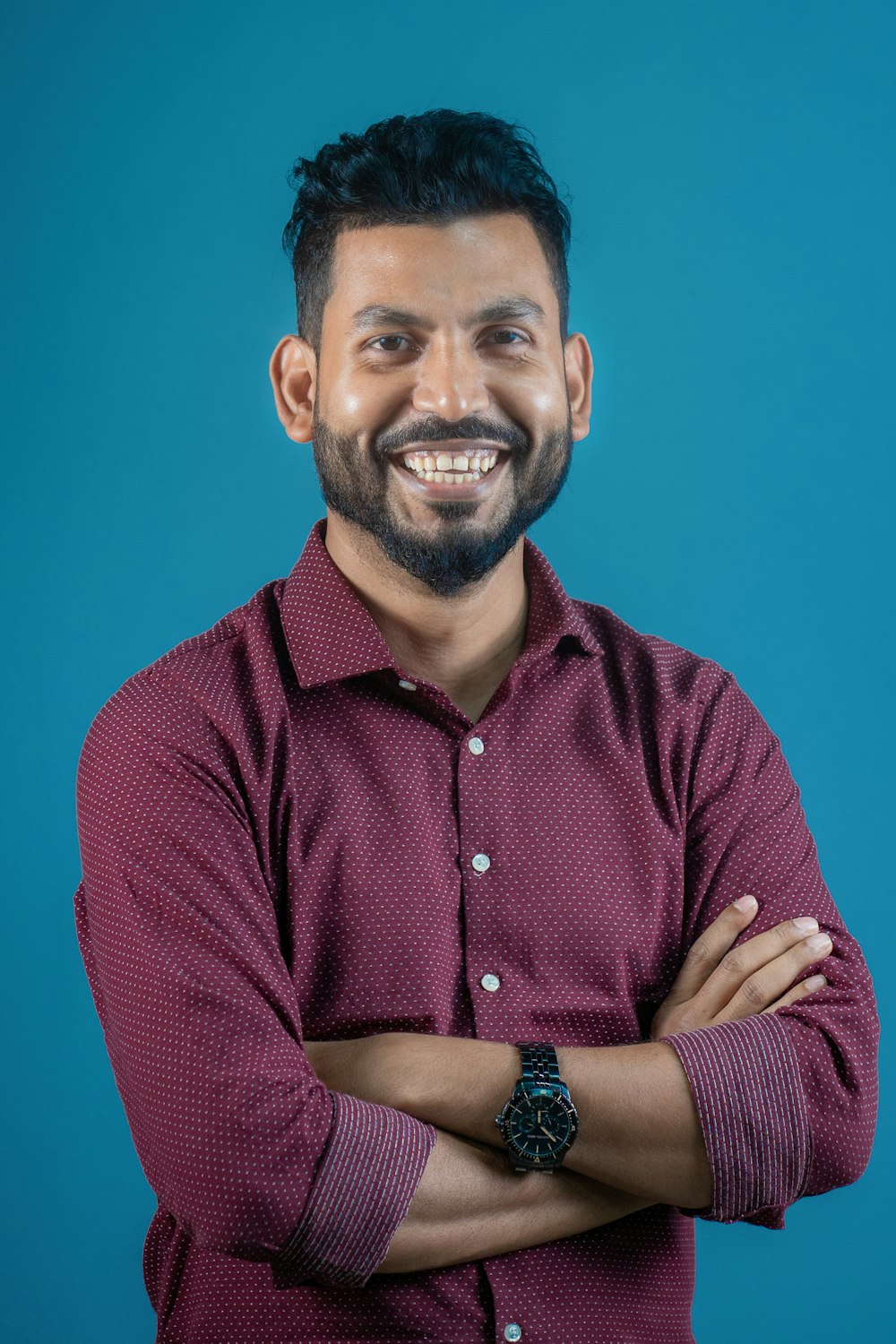 a man with his arms crossed smiling