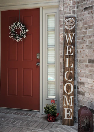 A charming front porch with a welcoming door and potted plants.