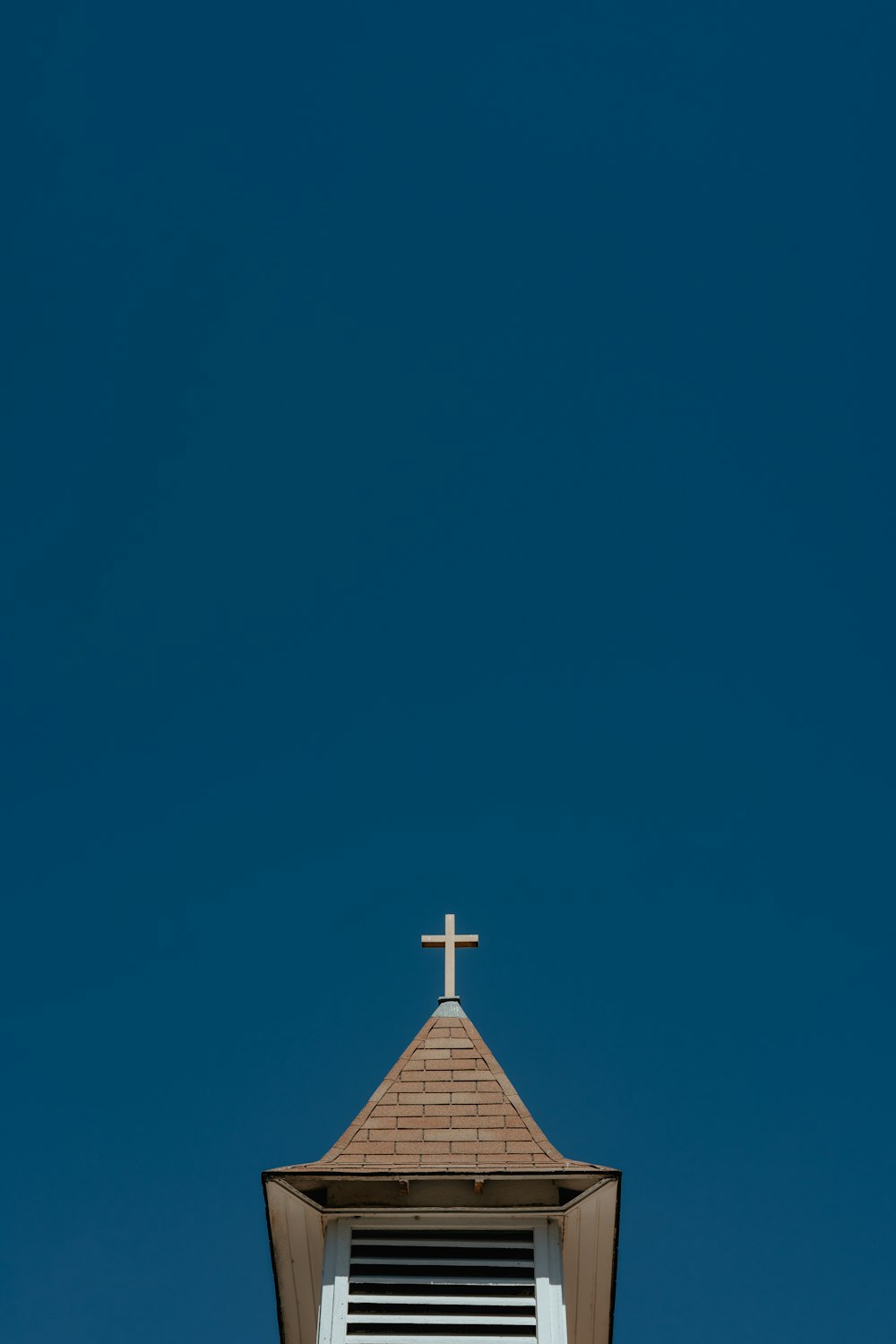 un clocher d’église avec une croix sur le dessus