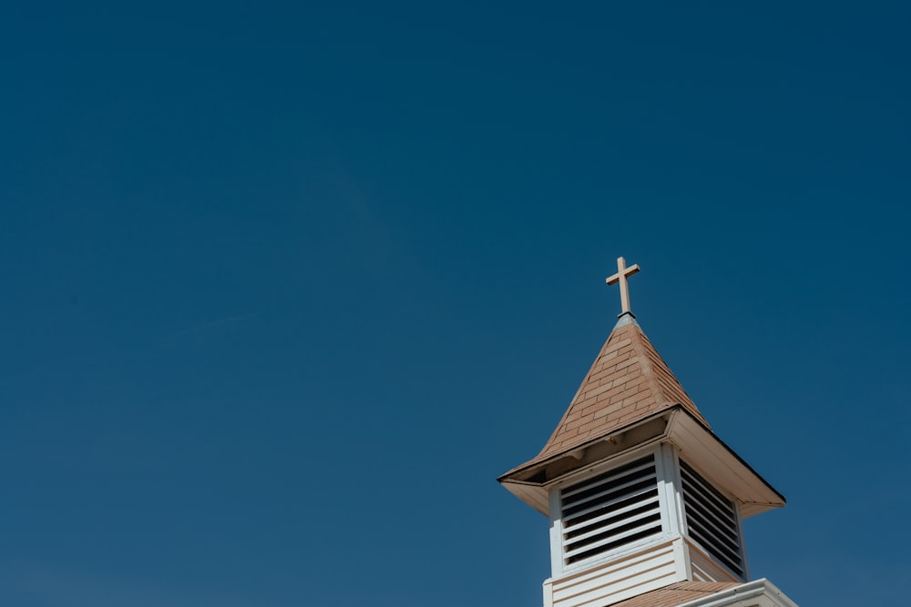 ein Kirchturm mit einem Kreuz auf der Spitze