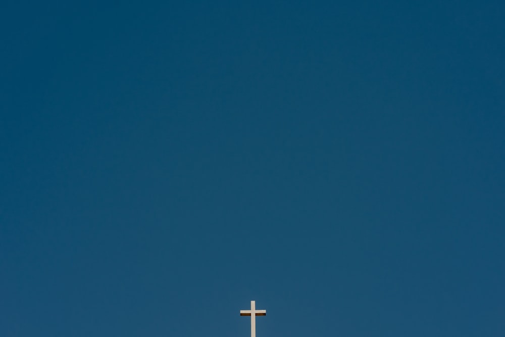 a cross on top of a building with a blue sky in the background