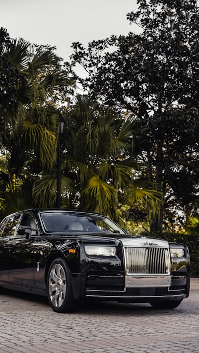 a black rolls royce parked in front of some trees on premium michelin tyres availabe at tyrepublic