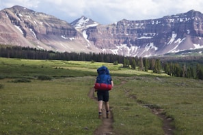 A traveler carrying a spacious backpack on a mountain trail.