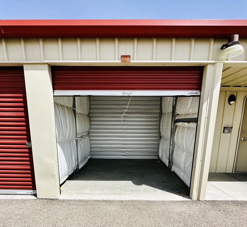 a red and white garage with a red roof