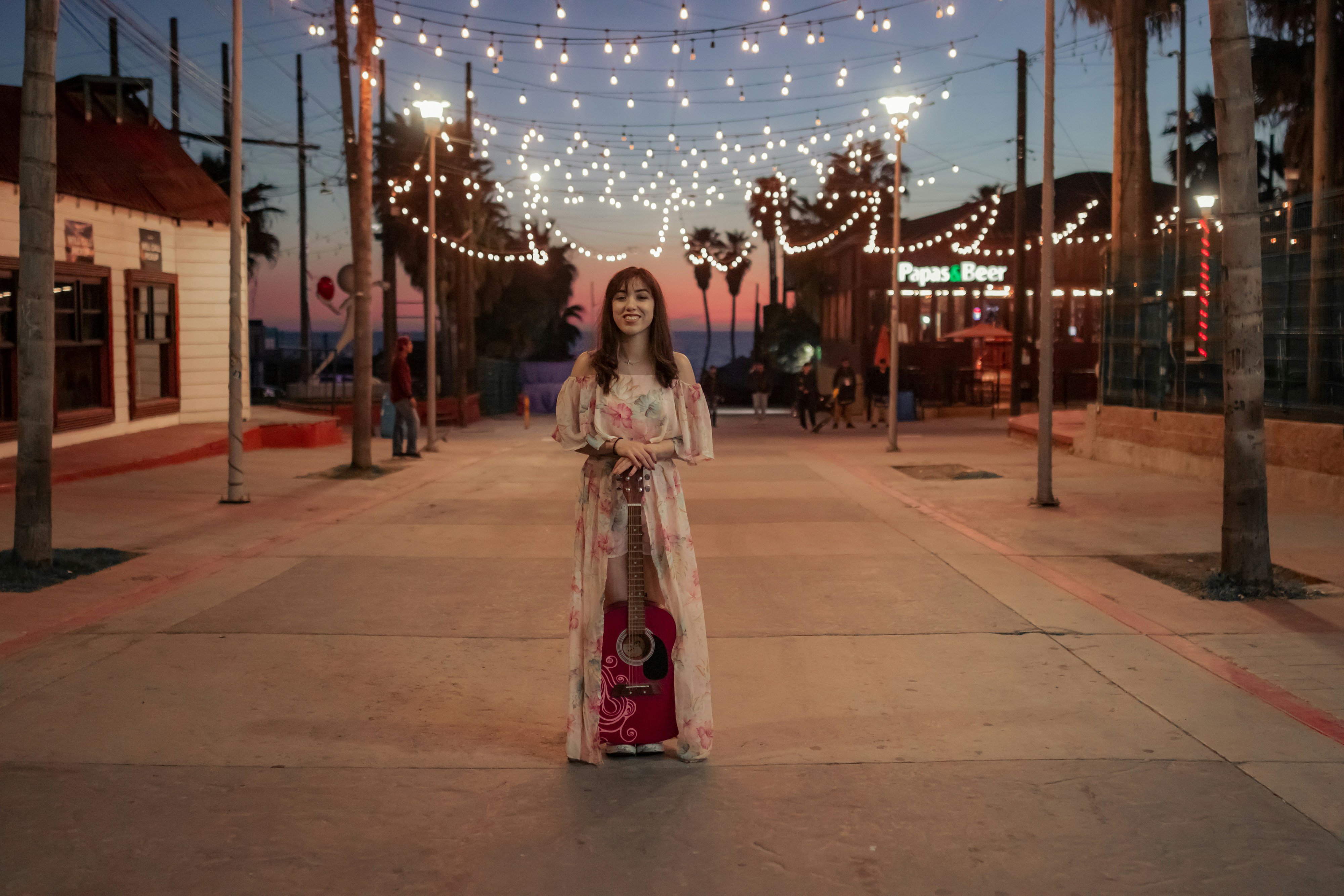 a woman in a long dress standing on a street