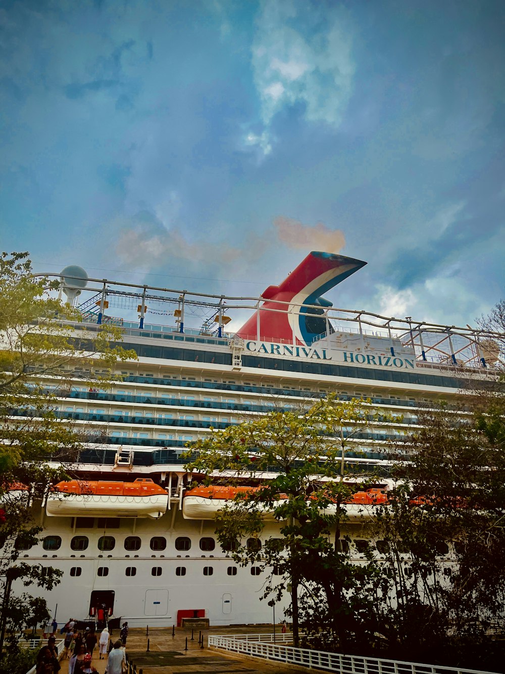 a large cruise ship with people standing on the deck