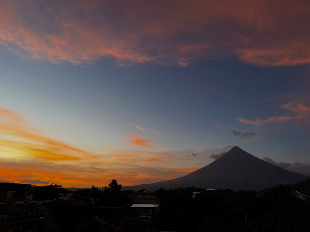 a sunset with a mountain in the background