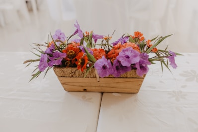 A charming handwoven basket filled with fresh flowers and personalized keepsakes on a rustic wooden table