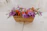 A beautifully arranged gift basket featuring gourmet treats and fresh flowers on a wooden table.