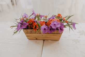 Elegant rattan baskets filled with fresh flowers on a rustic wooden table