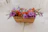 A beautifully arranged gift basket featuring gourmet treats and fresh flowers on a wooden table.