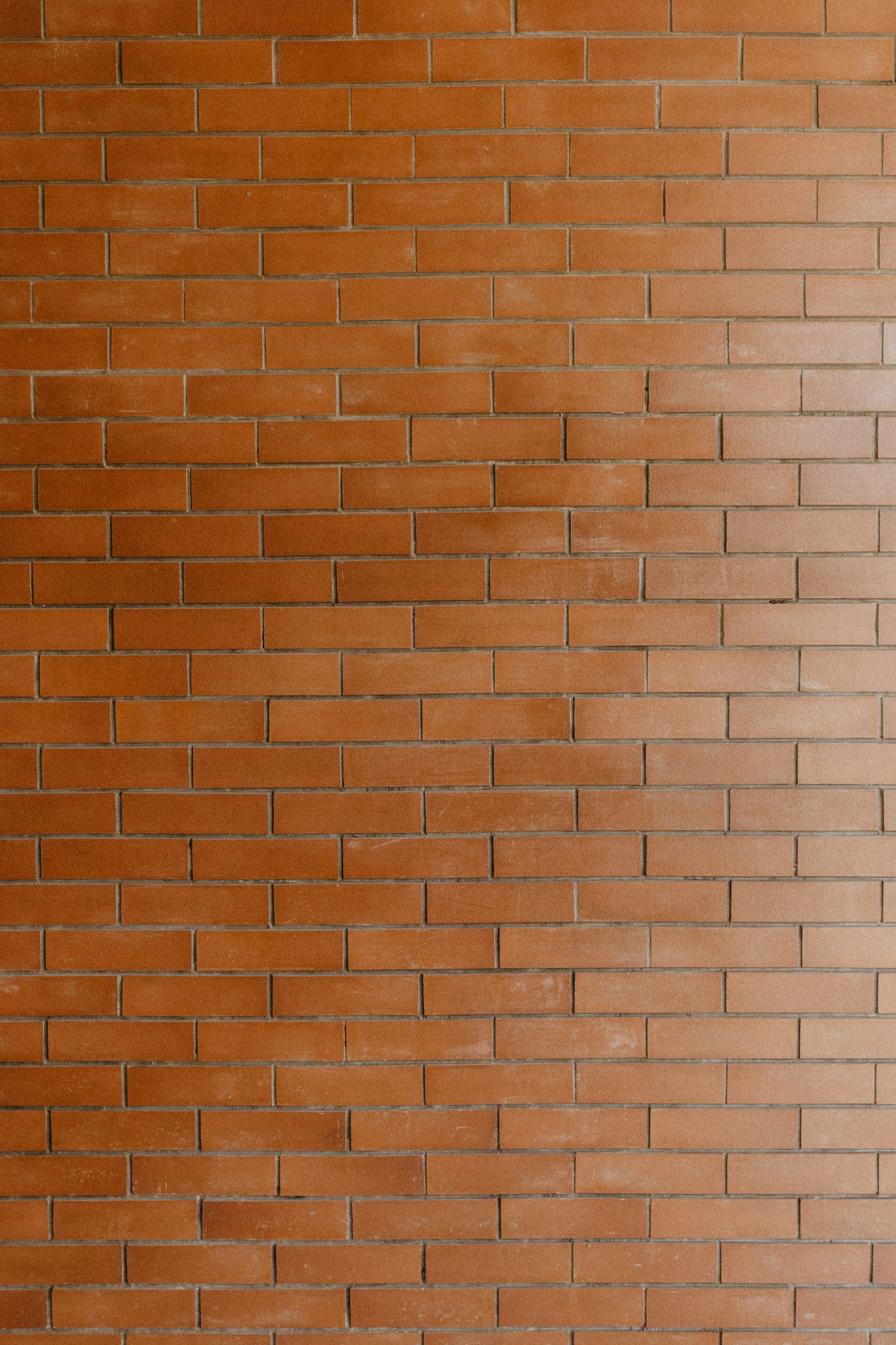 a red fire hydrant in front of a brick wall
