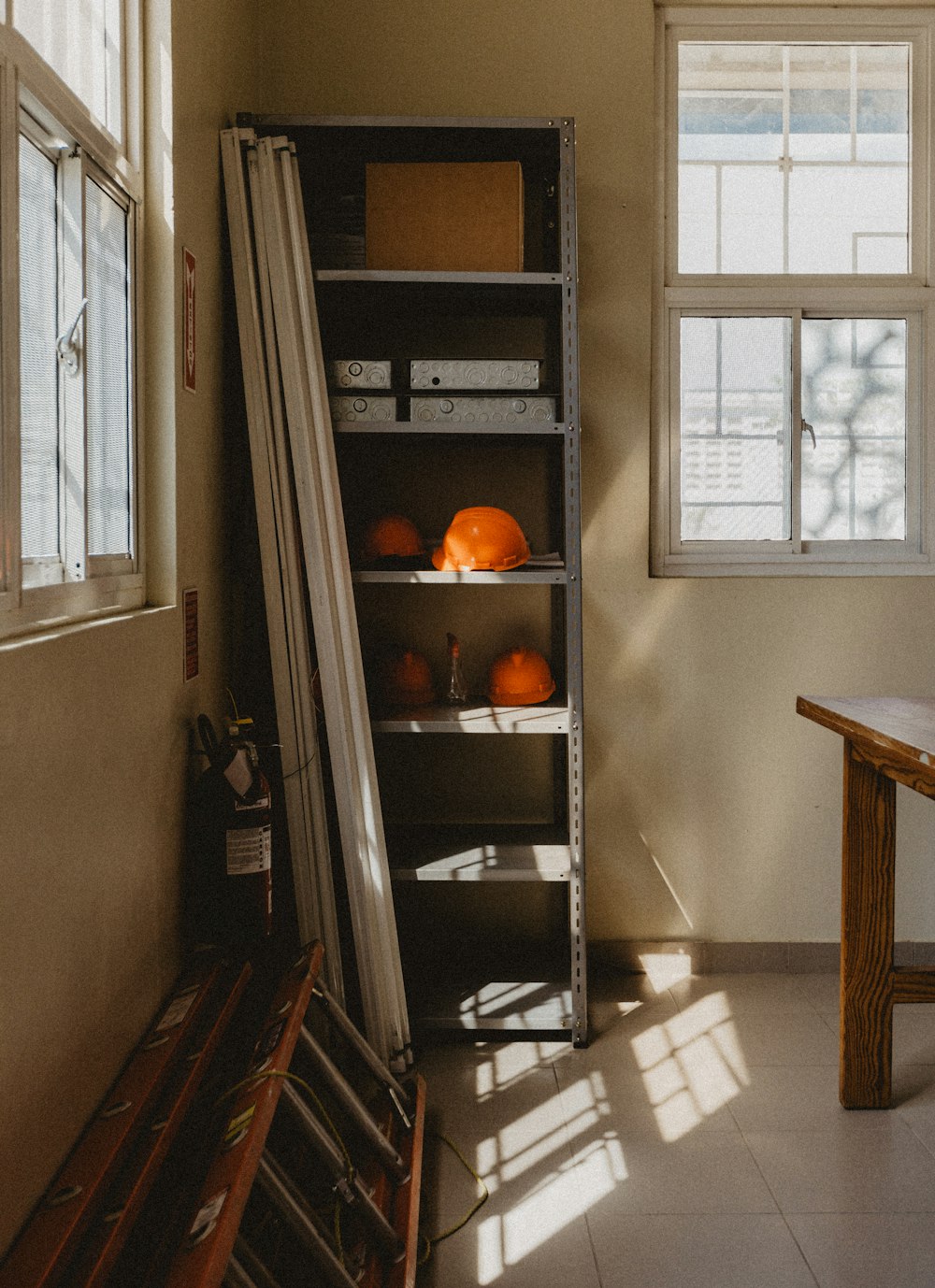 a room with a table and a shelf filled with oranges