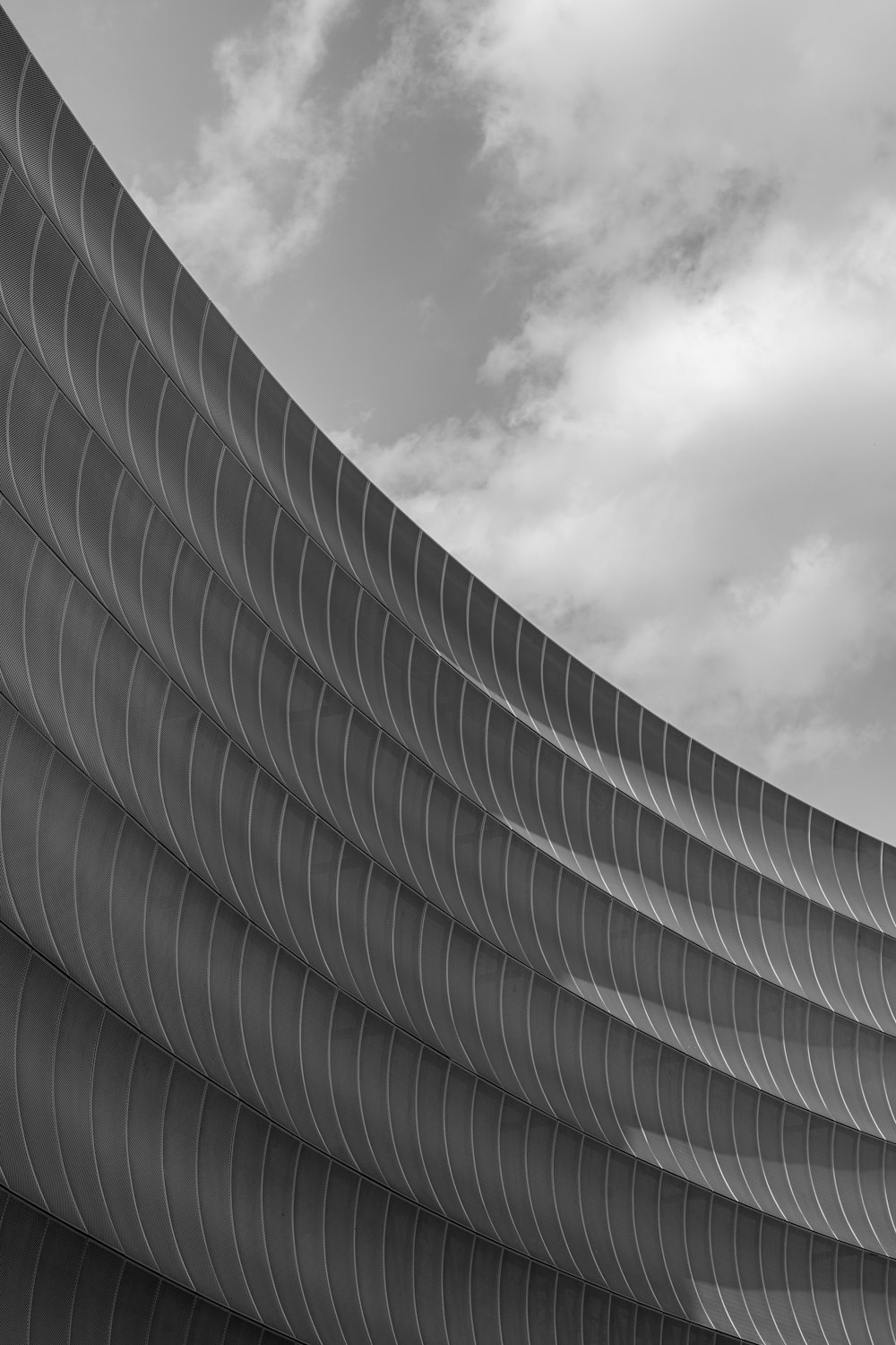 a black and white photo of a curved building