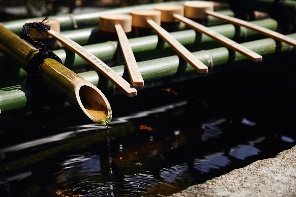 a row of bamboo poles sitting on top of a body of water