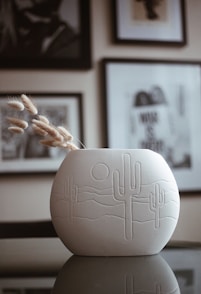 a white vase sitting on top of a table