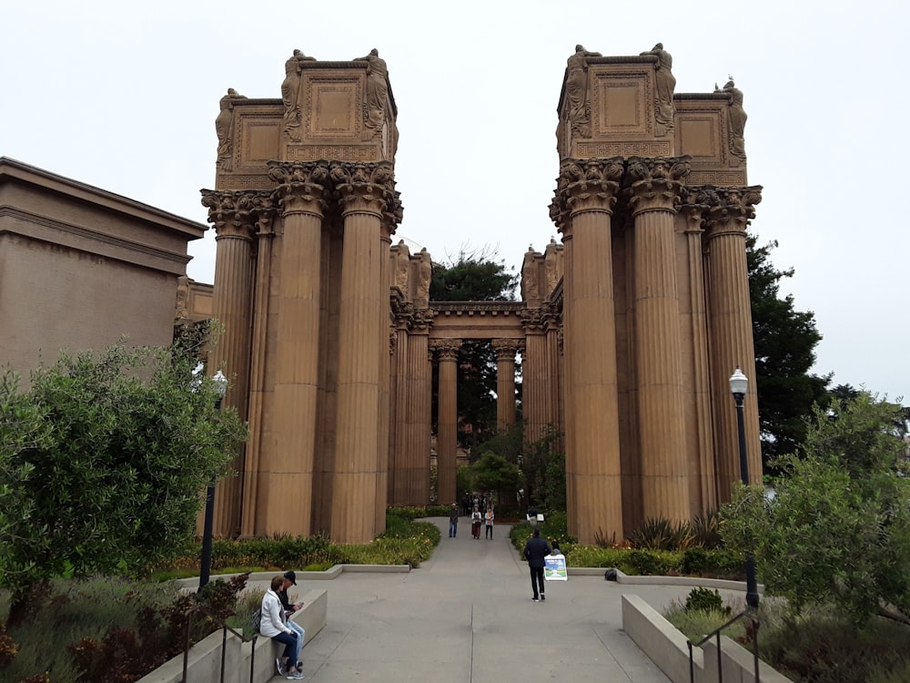 a couple of people that are standing in front of some pillars