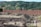 a large pile of dirt next to a forest