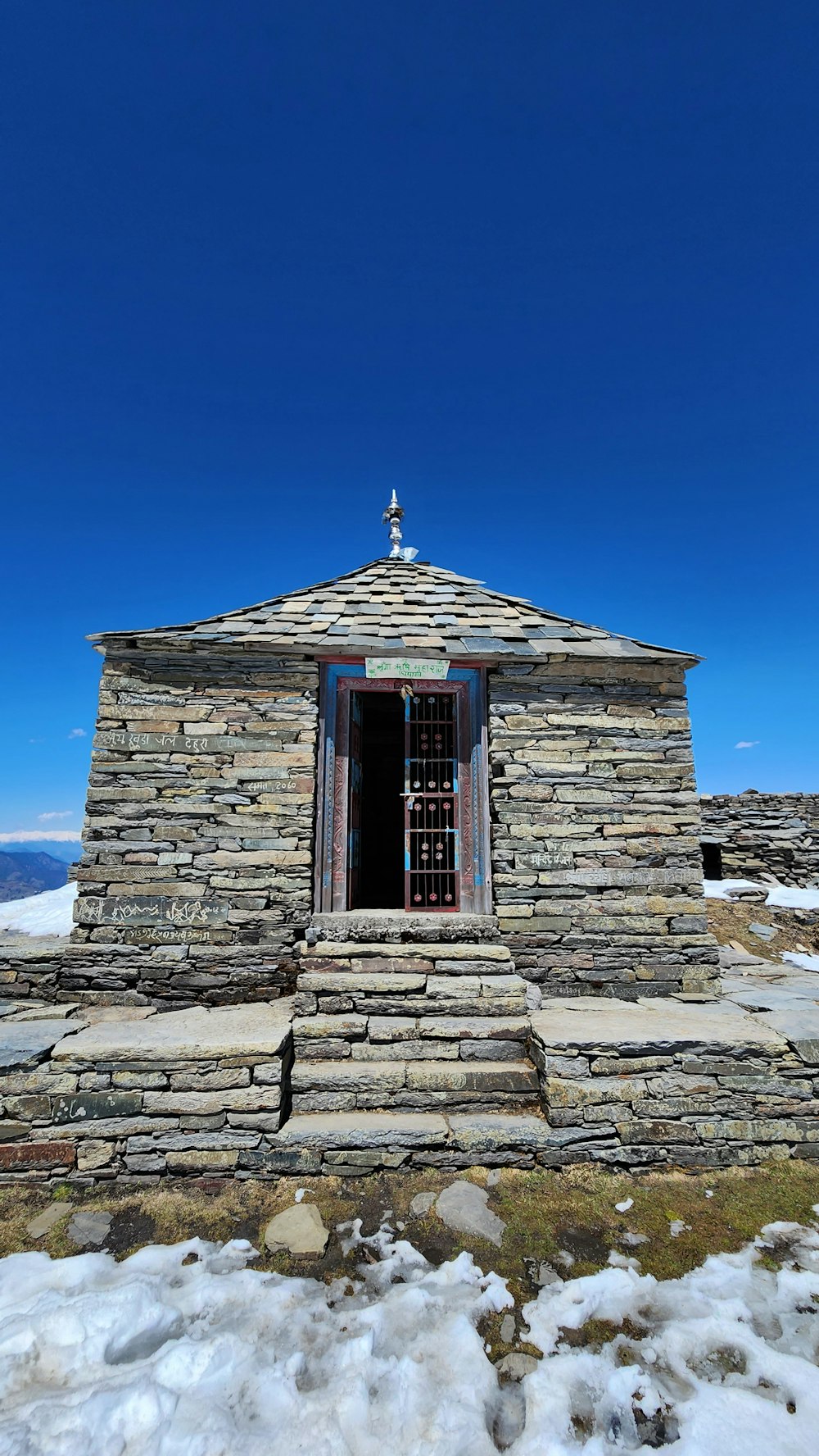 a small stone building with a cross on top of it