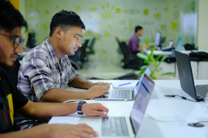 Portrait of a focused fintech team member working on a laptop in a modern office.