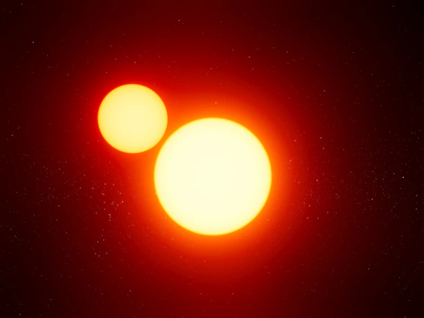 Two bright, glowing celestial bodies appear against a dark backdrop speckled with tiny stars. The larger sphere is intensely radiant in yellow and orange hues, while the smaller orb, positioned above and to the left, emits a softer yellow glow.