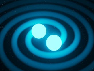 Two glowing blue spheres are positioned centrally, surrounded by circular ripples expanding outward on a dark background. The image has a cosmic or scientific theme, possibly representing gravitational waves or a similar astronomical phenomenon.