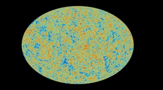 A large, elliptical, multicolored pattern with intricate blue, orange, and green textures on a black background, resembling a cosmic or astronomical map.