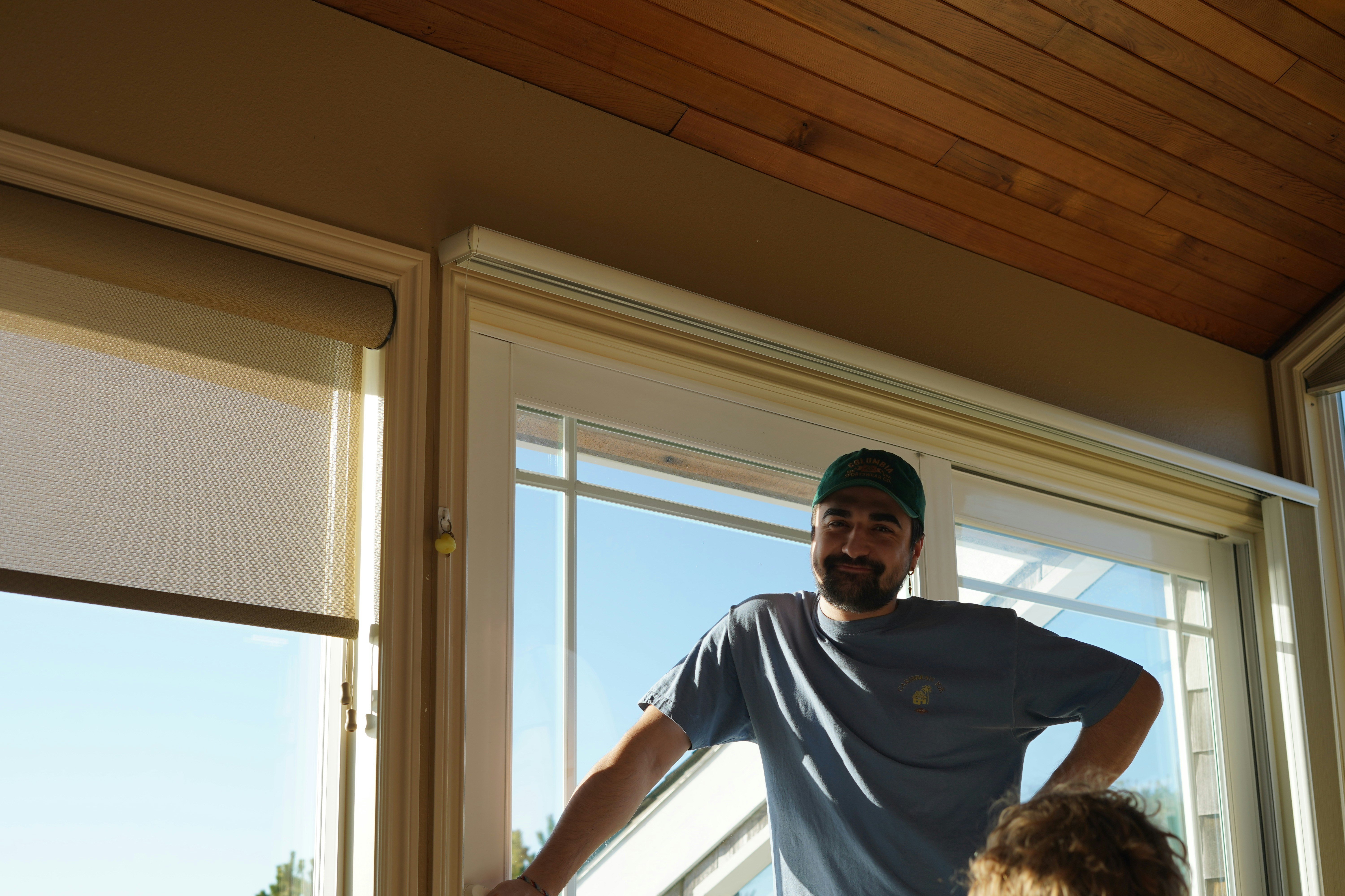 a man standing in front of a window next to a little girl