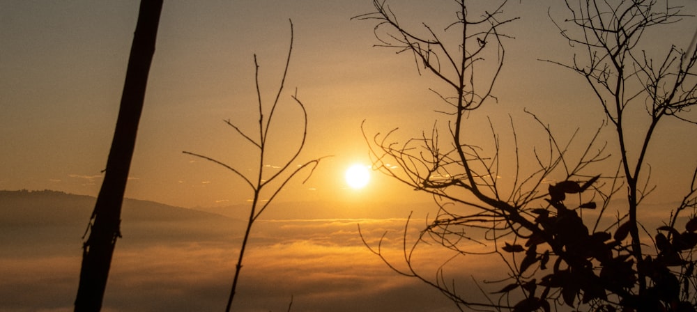 the sun is setting over the clouds in the sky