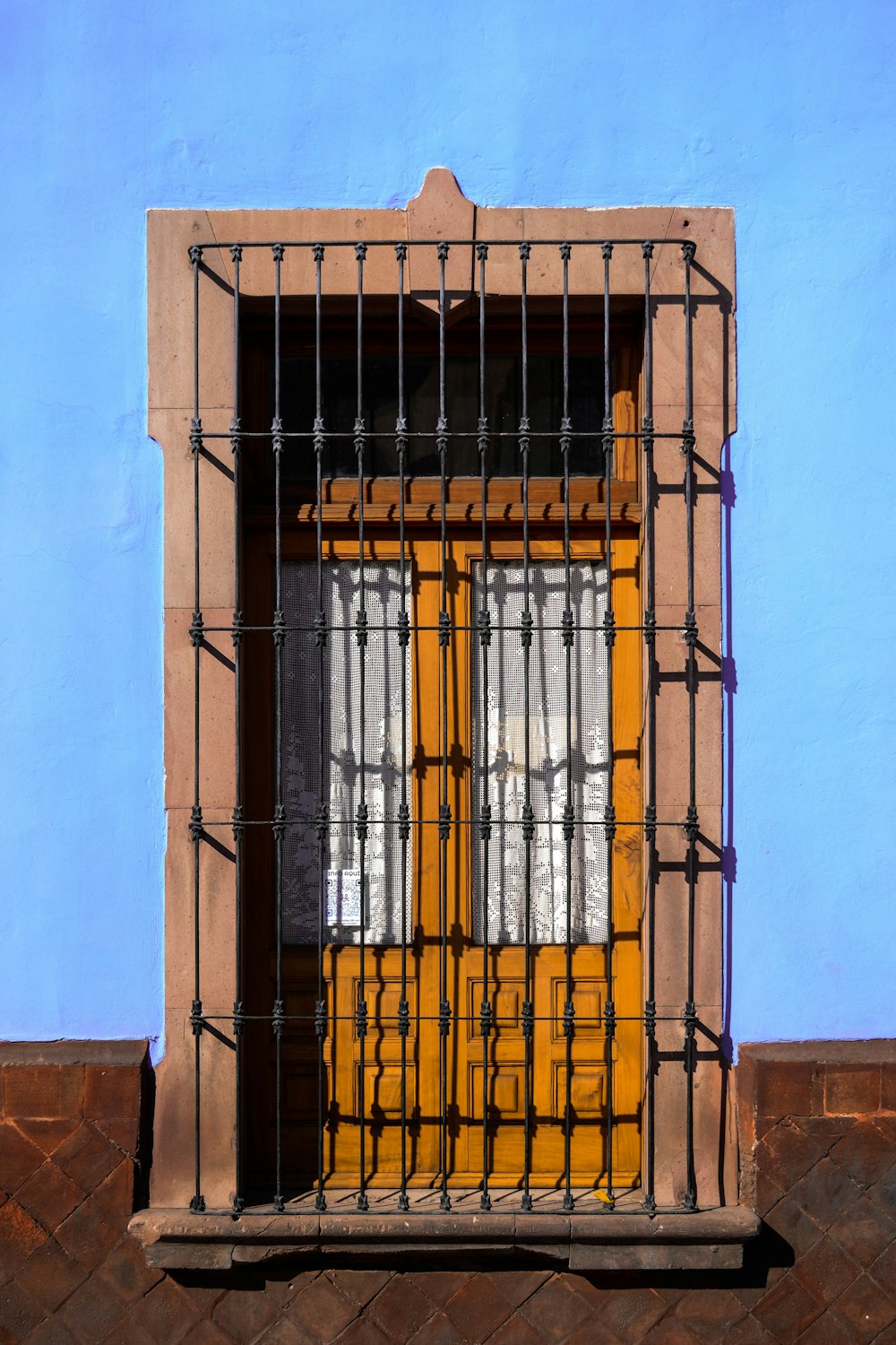 a window with bars and a yellow door