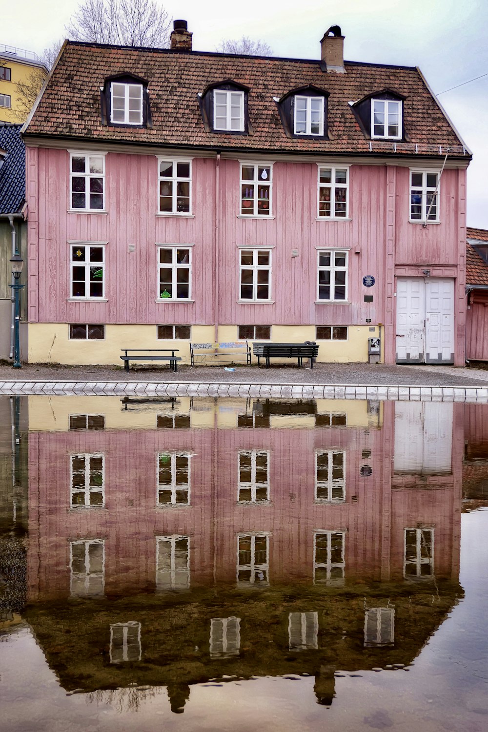 a pink building with a bench in front of it